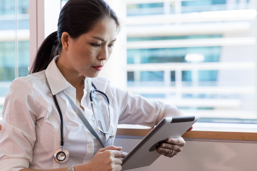 Médico verificando tablet para obter informações de paciente