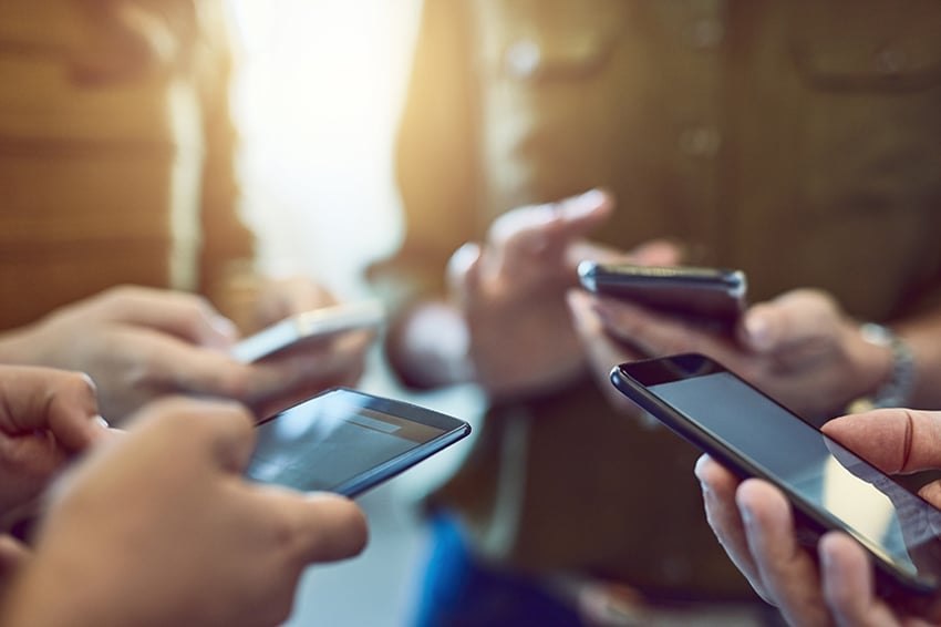 Grupo de pessoas utilizando smartphones em sincronia