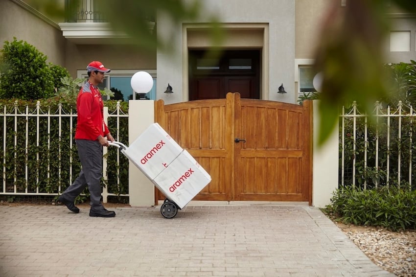 Entregador da Aramex entregando pacotes